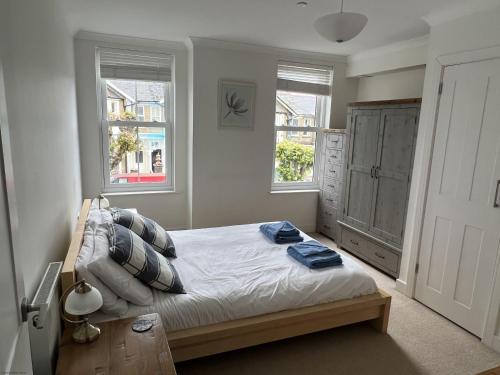 a bedroom with a bed and two windows at The Sanctuary in Sandown