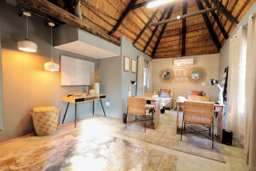 a living room with a table and a dining room at Tshukudu Game Lodge in Hoedspruit