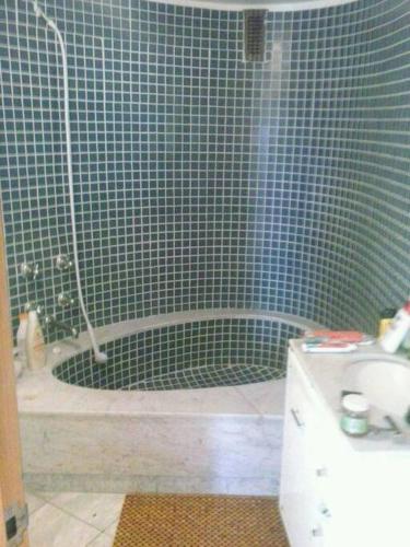 y baño con ducha de azulejos azules y bañera. en Personal Suite, en Ciudad de México