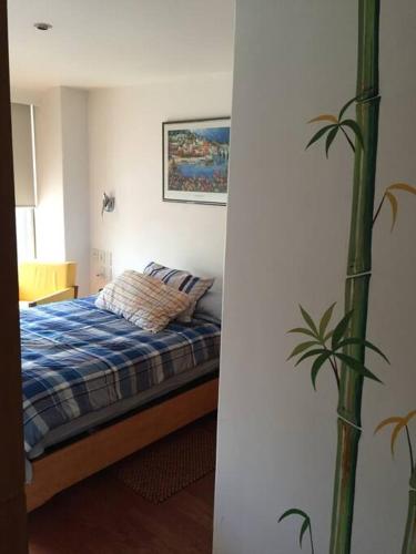 Un dormitorio con una cama y una planta. en Personal Suite, en Ciudad de México