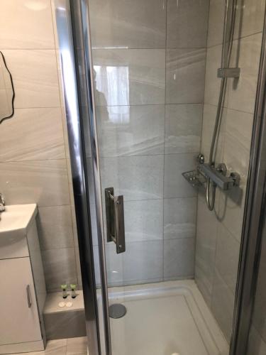 a bathroom with a shower with a glass door at Parkwood Hotel in London