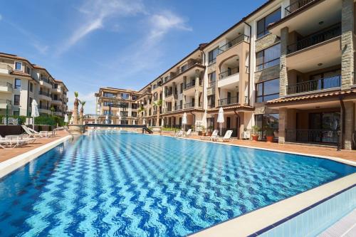 a swimming pool in front of some apartment buildings at Burgas Beach Resort 2 Apartments in Burgas