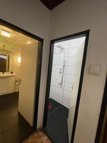 a bathroom with a shower and a glass door at HOSTEL LOVELY ROOMS CITY CENTER, shared Bathroom in Villach