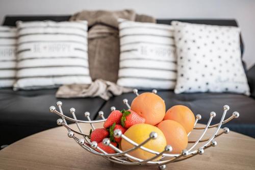 a bowl of fruit on a table in front of a couch at Apartments Frauensee in Reutte
