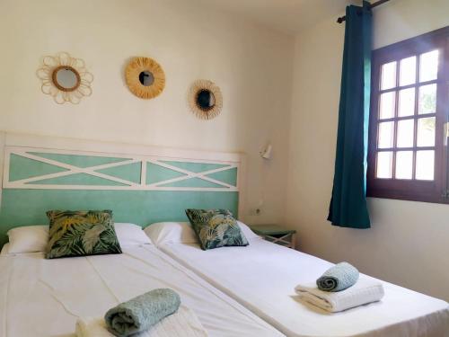 a bedroom with two beds with towels and a window at Cheap & Chic Apartamentos en Son Bou de 2 dormitorios in Son Bou