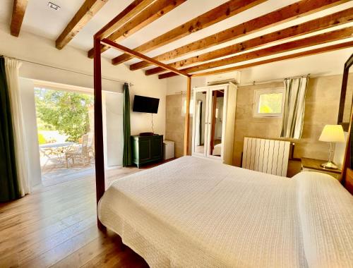 a bedroom with a large bed and a balcony at Finca Hotel Son Pont in Puigpunyent