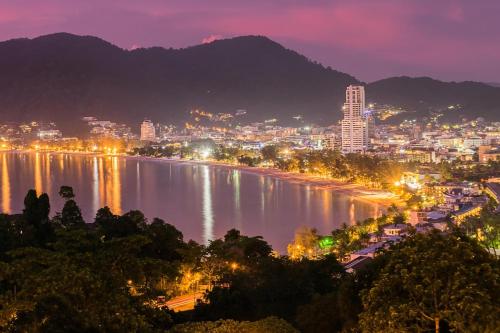 a view of a city and a river at night at Patong Tower apartment by Lofty in Patong Beach