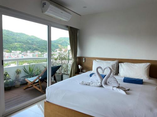 two swans towels sitting on a bed in a bedroom at Patong Tower Condominium by Lofty in Patong Beach