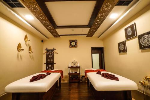 a room with two beds and a clock on the wall at Shahpura House in Jaipur