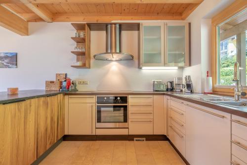 a kitchen with white cabinets and a sink at Chalet Oxygen in Fürth