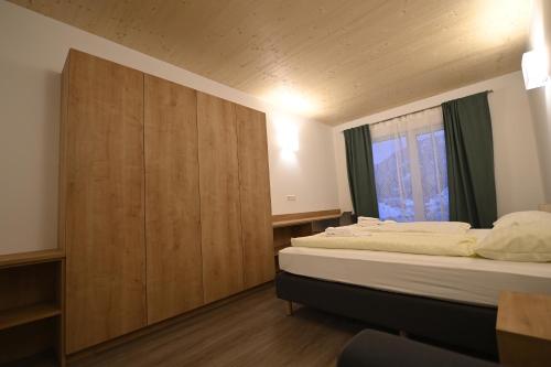 a bedroom with two beds and a wooden wall at Campus Ferlach in Ferlach