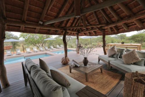a patio with couches and a table and a pool at Tshukudu Game Lodge in Hoedspruit