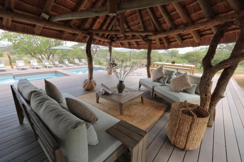 a patio with couches and a table and a pool at Tshukudu Game Lodge in Hoedspruit