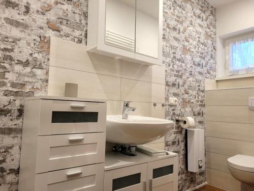 a white bathroom with a sink and a toilet at Ferienhaus Kranichzauber in Klausdorf Mecklenburg Vorpommern