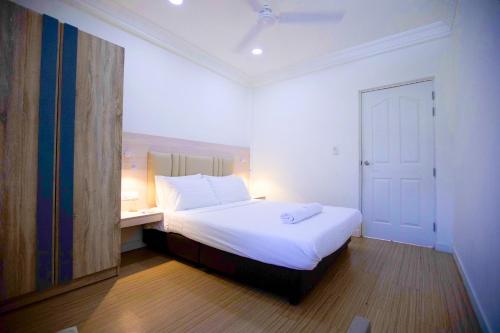 a bedroom with a white bed and a desk with a mirror at Keyla Inn in Thulusdhoo