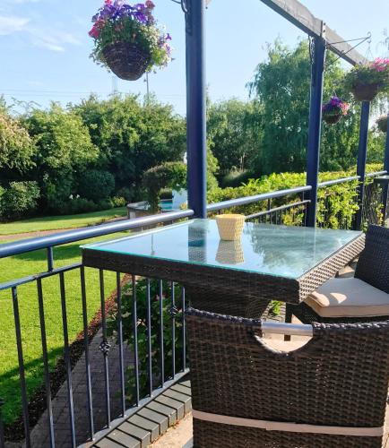 a patio with a glass table and chairs on a balcony at Best Western Thurrock Hotel in Grays Thurrock