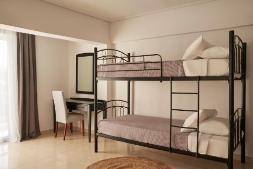 a bedroom with two bunk beds and a desk at Xenia Poros Image Hotel in Poros