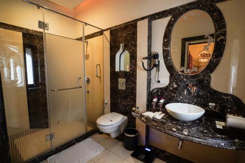 a bathroom with a sink and a toilet and a mirror at Shahpura House in Jaipur