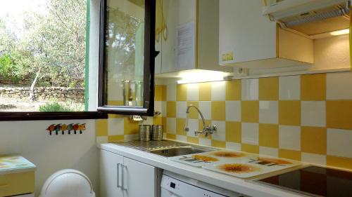 une petite cuisine avec un évier et une fenêtre dans l'établissement villa Terre Brûlée, à Ceyreste