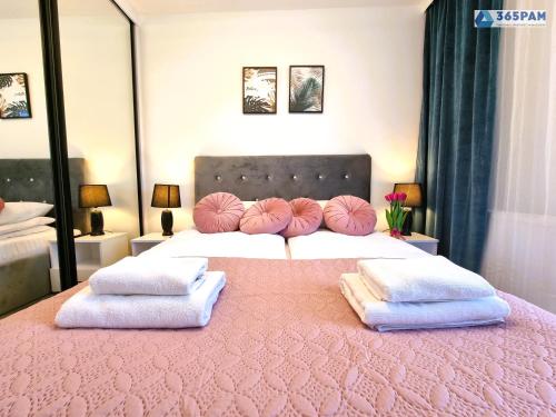 a bedroom with a large pink bed with two pillows at Apartamenty Na Fali w Gąskach - 365PAM in Gąski