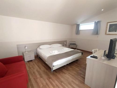 a bedroom with a bed and a red couch at Scicli Albergo Diffuso in Scicli