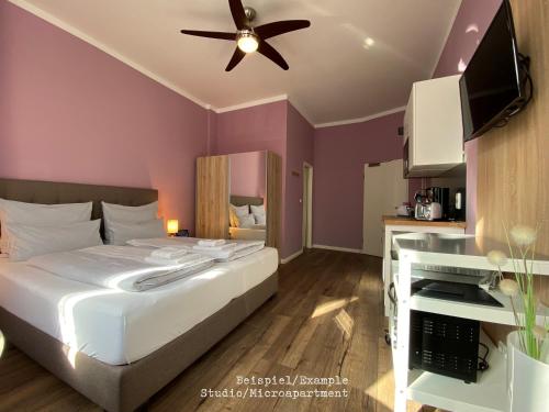 - une chambre avec un lit et un ventilateur de plafond dans l'établissement Amaroo - Gästehaus Potsdam “Charlottenhof”, à Potsdam