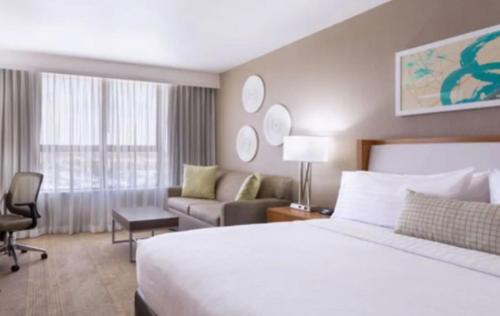 a hotel room with a bed and a couch at Holiday Inn Miami West - Airport Area by IHG in Hialeah Gardens