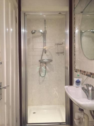uma casa de banho com um chuveiro e um lavatório. em Cricketers Cottage B&B em Kent