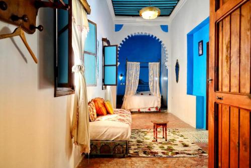 una camera con pareti blu e un letto in una stanza di Riad Khmisa a Tétouan