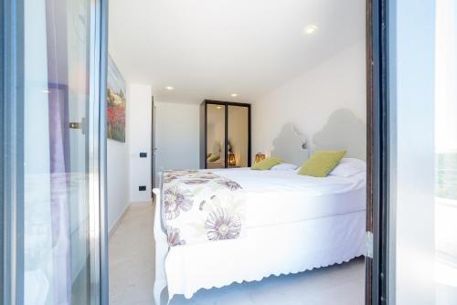 a bedroom with a white bed and a mirror at Villa Lustica in Lustica