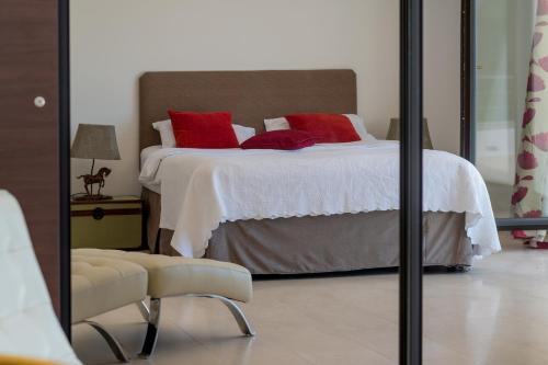 a bedroom with a bed with red pillows and a mirror at Villa Lustica in Lustica