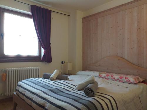 sypialnia z łóżkiem i oknem w obiekcie Love chalet w Livigno