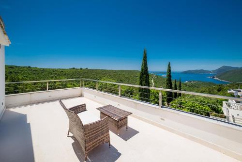 a patio with two chairs and a table on a balcony at Villa Lustica in Lustica