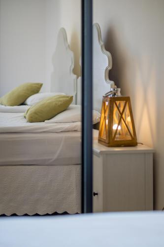 a mirror reflection of a bed with a lamp on a table at Villa Lustica in Lustica