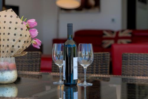 a bottle of wine sitting on a table with two wine glasses at Villa Lustica in Lustica
