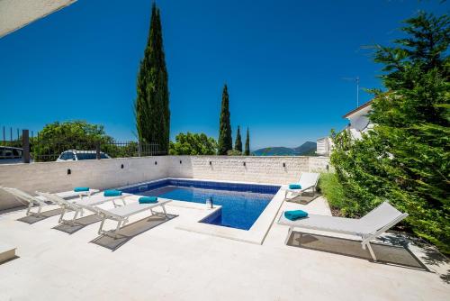 a swimming pool with lounge chairs and a swimming pool at Villa Lustica in Lustica