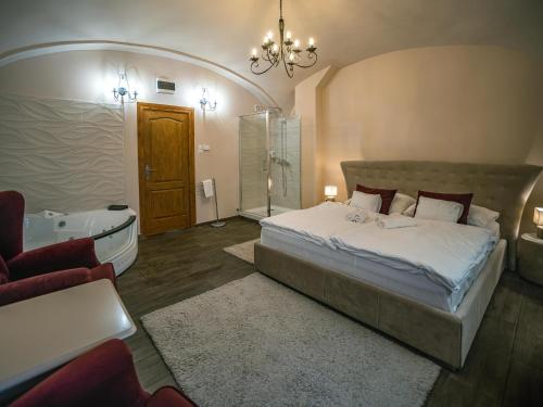 a bedroom with a large bed and a bath tub at Régi Posta Hotel és Étterem in Debrecen