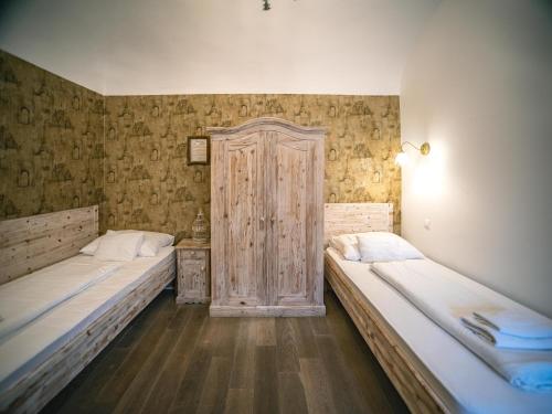 a room with two beds and a wooden door at Régi Posta Hotel és Étterem in Debrecen