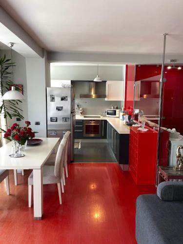 a kitchen with a white table and red cabinets at Metro Suites in Tirana