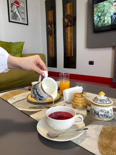 a person is stirring a cup of tea on a table at Metro Suites in Tirana