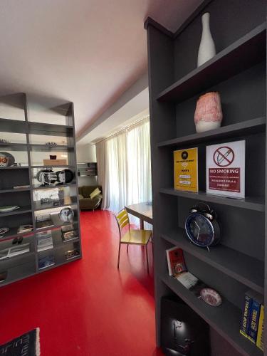 a room with a red floor and shelves with a table at Metro Suites in Tirana