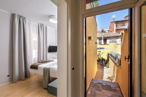 Un dormitorio con una cama y vista a un balcón. en Viam 16b Suites, en Roma