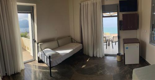 a bedroom with a bed and a balcony with the ocean at Horizon Beach Hotel in Plakias