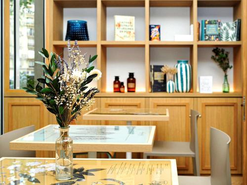 a table with a vase of flowers on top of it at ibis Styles Paris Gare De Lyon TGV in Paris