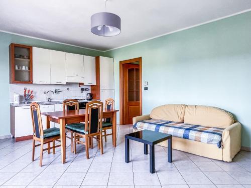 eine Küche und ein Wohnzimmer mit einem Tisch und einem Sofa in der Unterkunft MYHOUSE INN TORINO 1 - Affitti Brevi Italia in Collegno