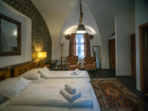 a bedroom with a large bed with towels on it at Régi Posta Hotel és Étterem in Debrecen