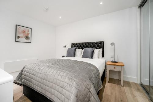 a white bedroom with a large bed and a table at Citystay - Finch House in Cambridge