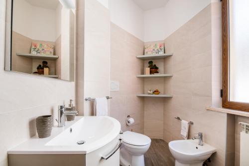 een badkamer met een wastafel, een toilet en een spiegel bij Montescudo Centro Apt a 5 min da San Marino x3 in Montescudo