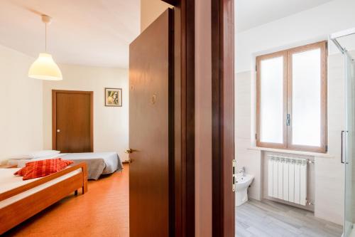 een slaapkamer met een bed en een badkamer met een raam bij Montescudo Centro Apt a 5 min da San Marino x3 in Montescudo