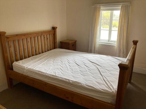 a bedroom with a bed with a wooden frame and a window at Norfolk Lodge - Dhilba Guuranda-Innes National Park in Inneston